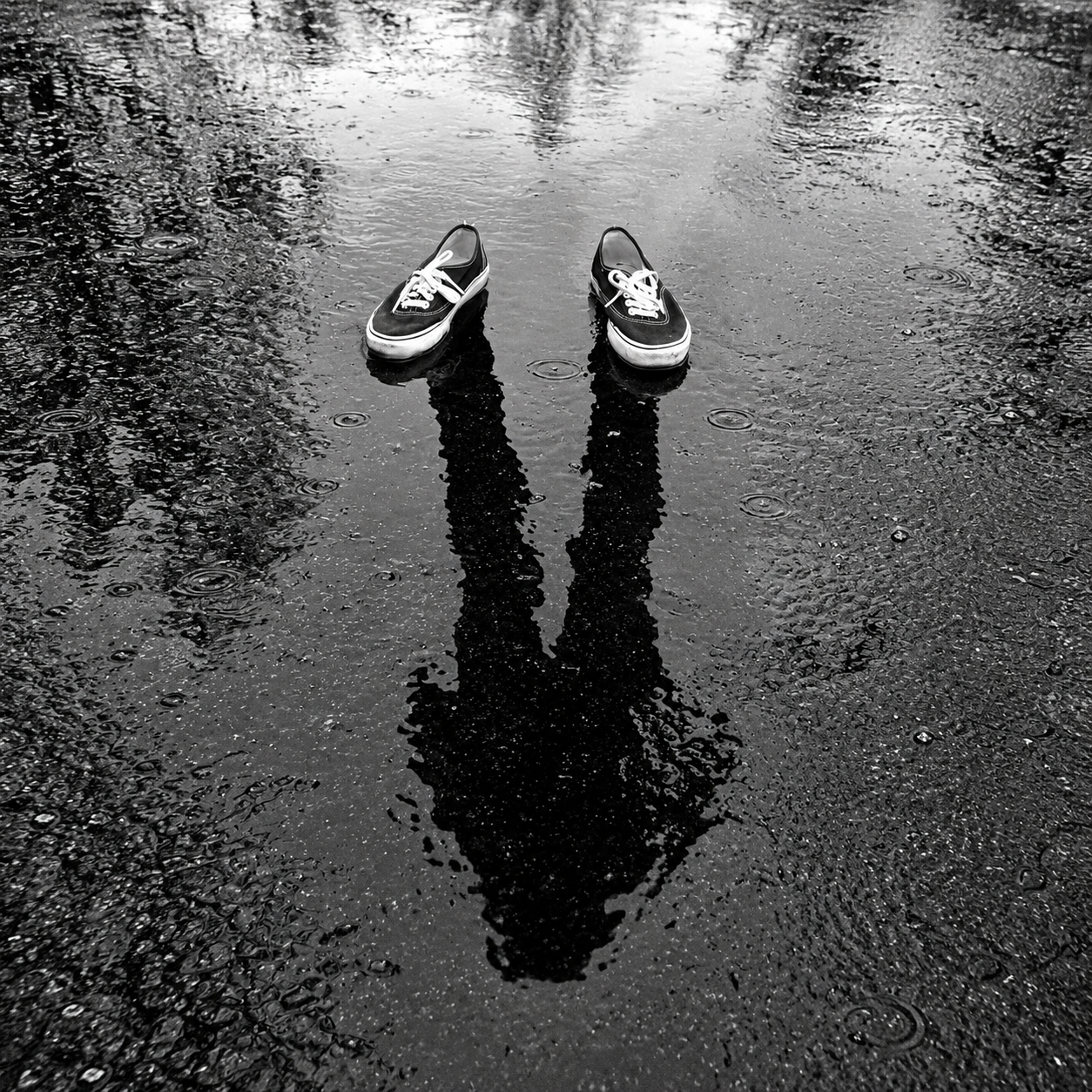 Shoes reflected in rain puddle